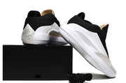 White and black Jordan 40 shoes posed with a black box, showing their side and heel details.