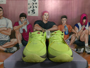 Front view of neon green Nike basketball sneakers showing the laces, mesh-like toe areas, and dark outsole details.
