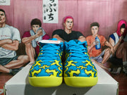 Front view of the pair showing blue laces, the blue-and-yellow graphic upper, and textured yellow outsoles.