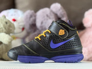Opposite side view showing the black upper, purple Swoosh-style accent, gold-yellow laces and ankle detail.