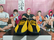 Front view of the pair showing black toe areas, yellow upper detailing, and yellow laces.