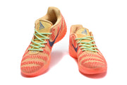 Front view of orange Nike basketball sneakers with mint-green laces and blue swoosh details.