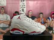 Side profile of a white high-top sneaker showing perforated panels, red sole accents, and a visible air window.