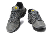 Front view of the grey sneakers with yellow tongue badges and lace-up closures.