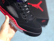 Close-up of the black toe box, laces, perforated side panel, and red midsole accent.