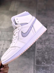 Close side view of the sneaker showing the gray side accent, white upper panels, padded collar, and textured outsole edge.