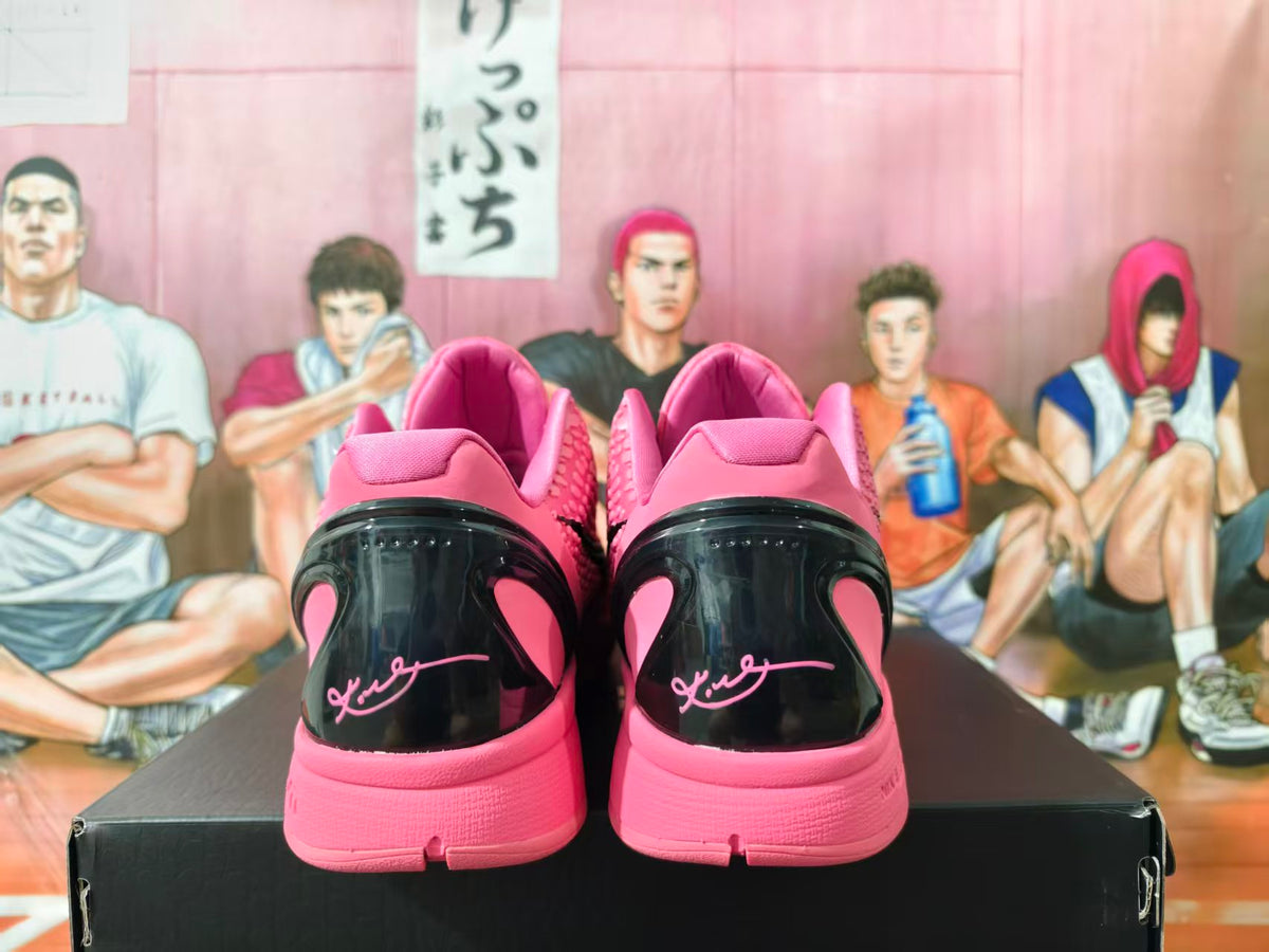 Rear view of pink and black basketball sneakers on a black shoebox, showing heel detailing and a Kobe signature-style marking.
