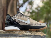 Side profile highlighting the light Swoosh, beige patterned upper, glossy black heel, and white midsole section.
