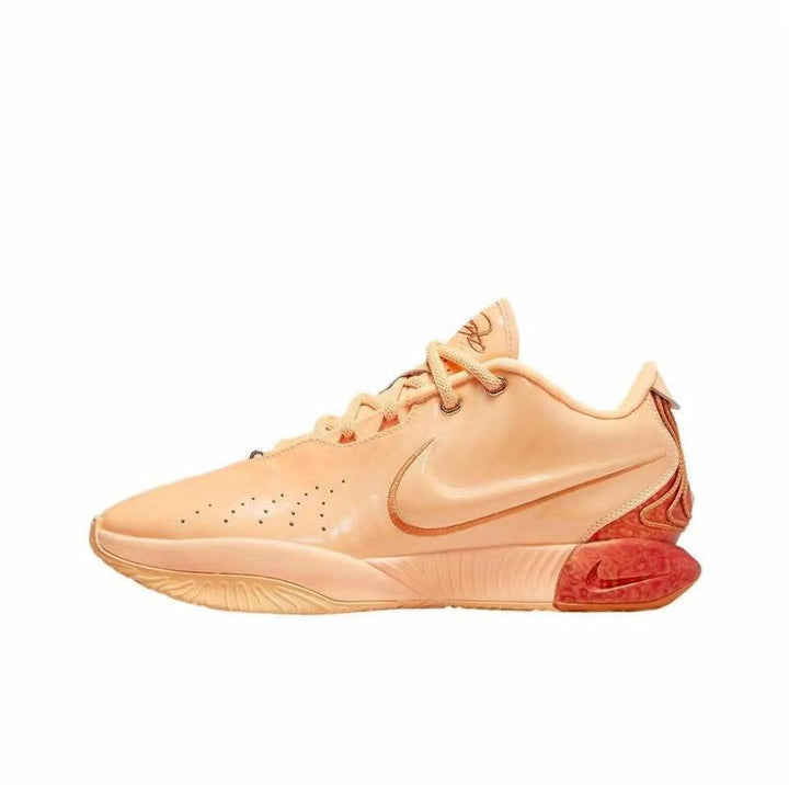 Peach-colored LeBron 21 basketball sneaker with a tonal Swoosh and contrasting red outsole detail.