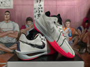 Angled view showing the perforated white upper, black details, and pink outsole of Nike Sabrina basketball shoes.