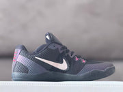 Side profile of a charcoal Nike Kobe 11 low-top with a white Swoosh and pink heel accents.
