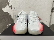 Front view of white Nike basketball shoes with black Swoosh details and bright pink side accents