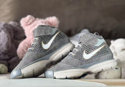 Pair of gray high-top sneakers angled to show the side detailing, padded ankle areas and textured outsoles.