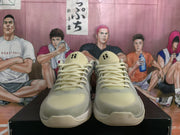 Front view of gray and pale yellow Nike basketball sneakers with cream laces and black tongue details.