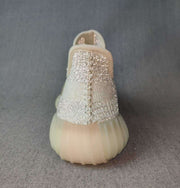 Rear view showing the padded heel collars, woven upper, and translucent cream outsole.