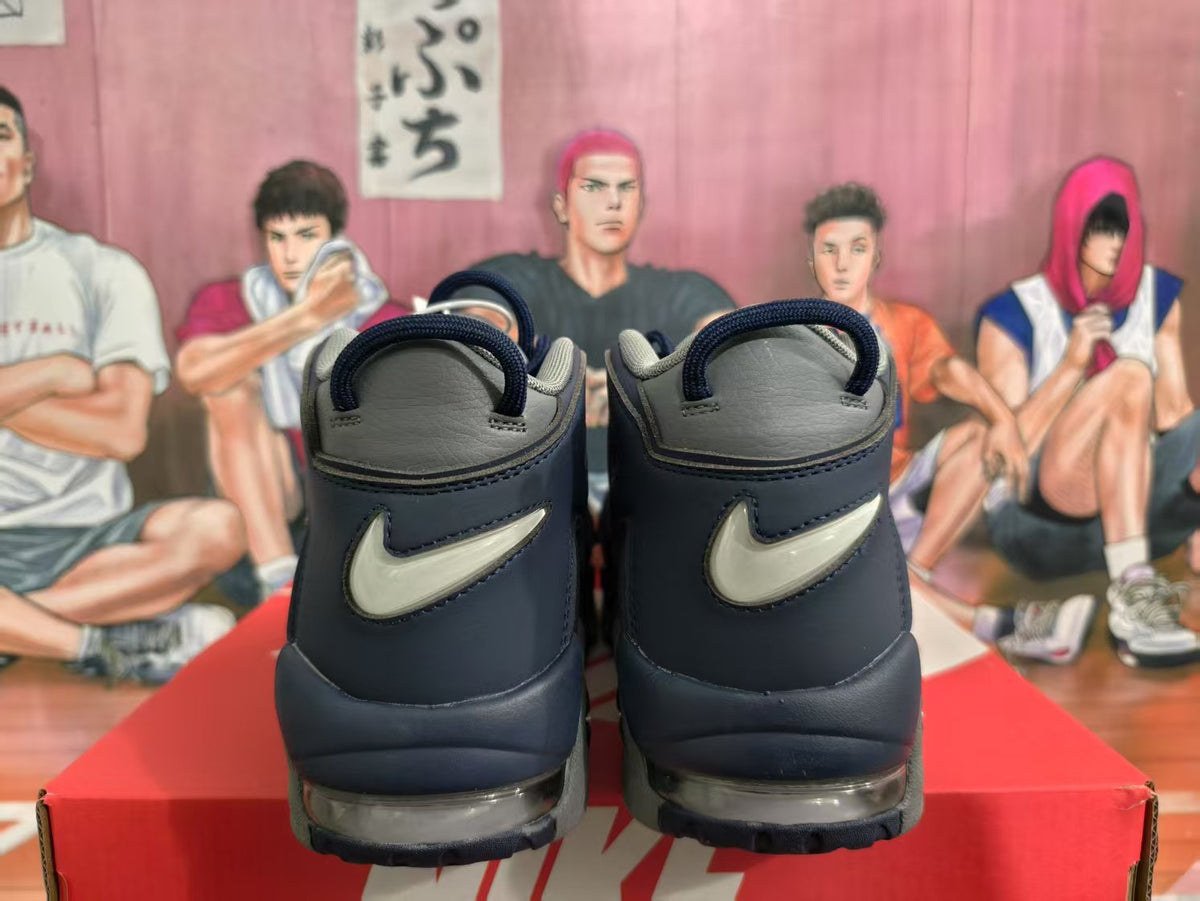 Rear view of navy and gray Nike high-top sneakers showing contrasting heel Swoosh branding and visible air units.
