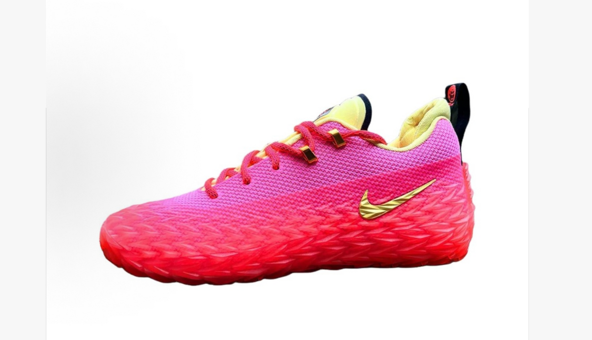 Pink low-top Nike sneakers with a textured upper, gold-tone Swoosh, red laces, and pale yellow lining.