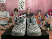 Front view of the pair showing grey laces, perforated toe areas and contrasting black and grey geometric patterns.