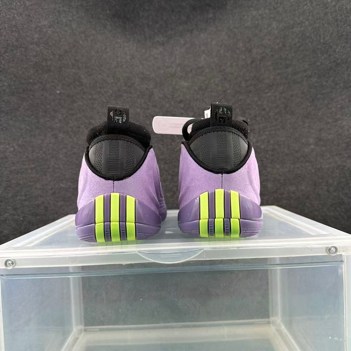 Rear view of purple Nike basketball shoes with black heel details and bright volt outsole accents