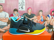 Side view of a Nike basketball shoe with black and gray upper, blue heel, yellow midsole accents and visible NIKE ZOOM text