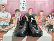 Front view of a pair of black lace-up sneakers with sculpted side panels.
