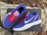 Angled overhead product view showing both sneakers, Kobe tongue emblems, red laces, white Swooshes, and heel panels.