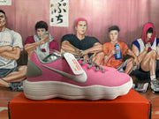Side profile of a pink Nike sneaker with grey heel detail and a white ridged outsole.