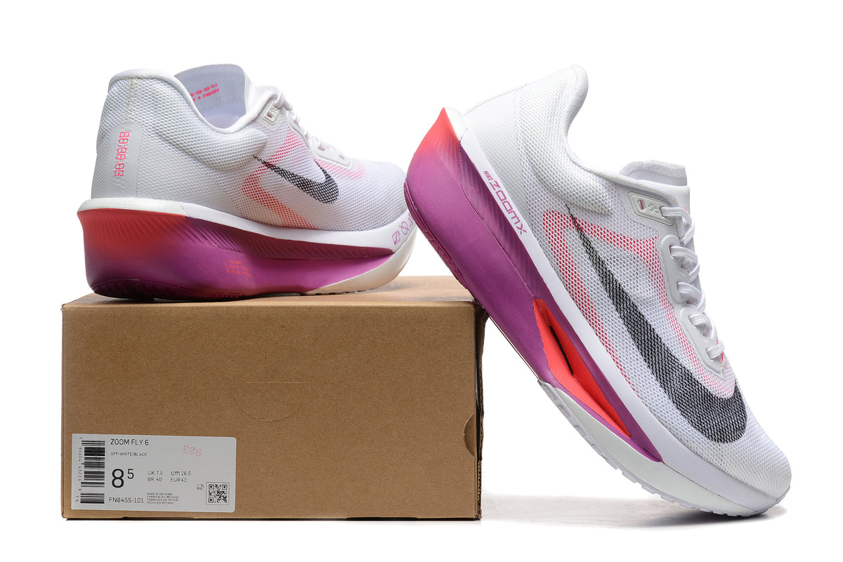 White Nike Zoom Fly 6 shoes with pink, purple, and black accents beside a box labeled Zoom Fly 6.