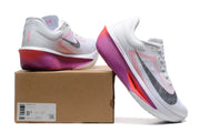 White Nike Zoom Fly 6 shoes with pink, purple, and black accents beside a box labeled Zoom Fly 6.