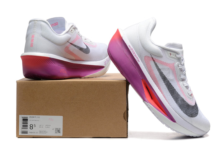 White Nike Zoom Fly 6 shoes with pink, purple, and black accents beside a box labeled Zoom Fly 6.