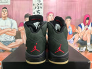Rear view of black high-top sneakers with red Jumpman heel branding and contrasting outsole sections, displayed on a shoebox.