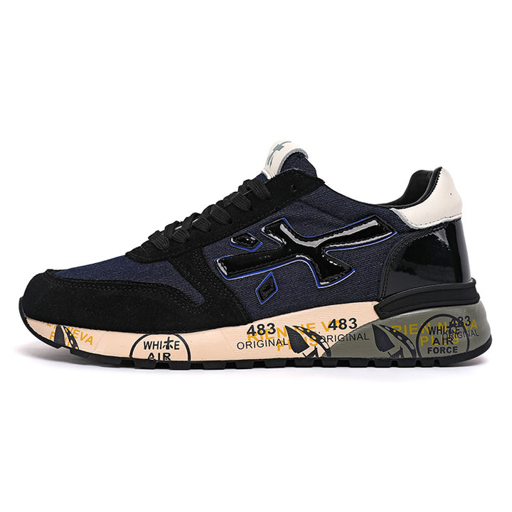 Side view of navy and black low-top sneakers with a prominent N-shaped logo, cream accents, and a graphic midsole.