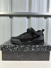 Single black Jordan Spizike Low sneaker shown in profile on a patterned shoebox.