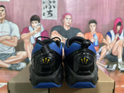 Rear view of the blue and black sneakers showing black heel panels and yellow heel emblems.