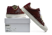 Burgundy sneakers displayed with a box bearing a Maison Margiela label