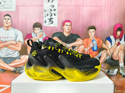 Side view showing the black upper, yellow sculpted midsole and outsole, and patterned laces.