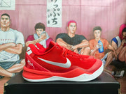 Side view of a red and white Nike basketball sneaker showing the lace-up upper, Swoosh, heel graphics, and white outsole.