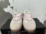 Front view showing pale pink laces and cream panels on Converse trainer-style sneakers