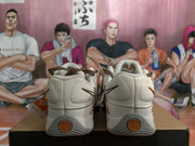 Rear view of the white Nike sneakers showing heel swooshes and orange circular heel details