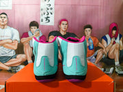 Rear view of the sneakers showing blue-green heel panels, white collars, pink trim, and black-and-purple soles.