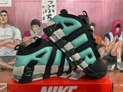 Angled side view of the black and green Nike sneakers highlighting the layered upper and segmented sole design.
