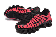 Pair of black and bright pink sneakers shown at an angle.