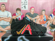 Black Nike basketball sneaker with red and orange side accents shown on a shoebox.