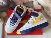 Top-down close view showing the purple laces, yellow Swooshes, white toe areas, and high-top collars.