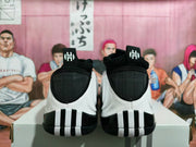 Rear view of black and white basketball shoes showing heel stripes and H tongue logos.