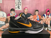 Side view of a black basketball sneaker with a yellow Swoosh-style mark, textured upper, dark midsole and yellow outsole detail.