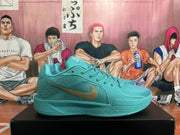 Side view of a lake-blue Nike Kobe basketball shoe with a gold-tone Swoosh.
