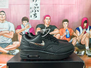 Side view of a black Nike sneaker with perforated detailing and a visible heel window