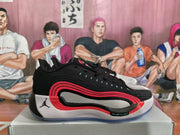 Side view of a black Jordan basketball sneaker with red and white layered details on a shoe box.
