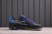 Side profile showing the low-top silhouette, black upper, purple laces, blue trim, and printed side text.